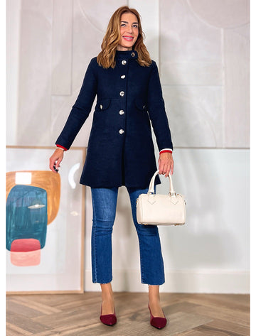 abrigo de mujer azul marino con doble botonadura combinado con vaqueros