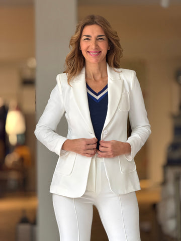 Conjunto básico de mujer con chaqueta blanca entallada y pantalón blanco, combinado con top azul marino.