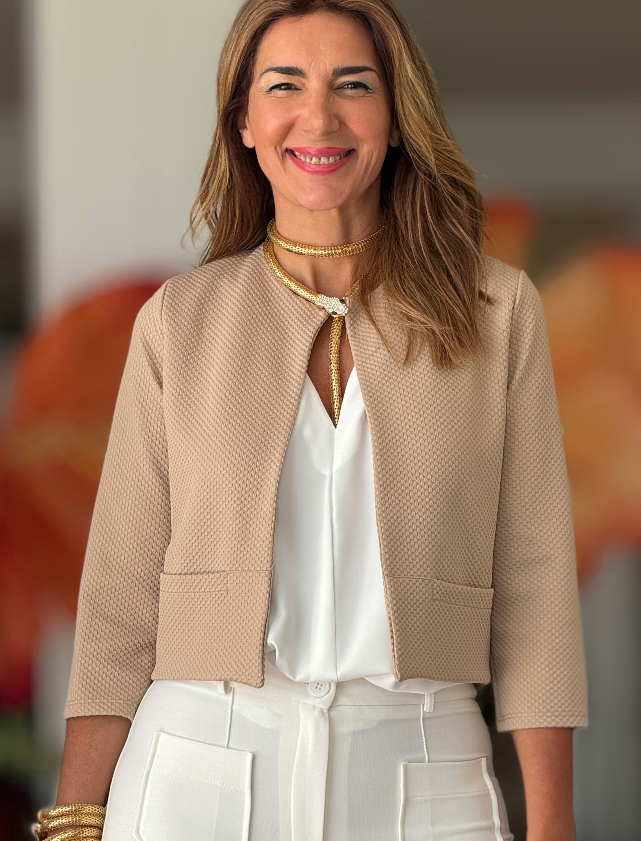 Detalle de blusa blanca con americana beige, mujer elegante
