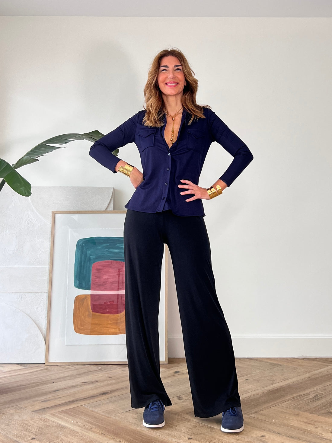 Camisa azul marino de mujer elegante combinada con pantalón oscuro sofisticado.