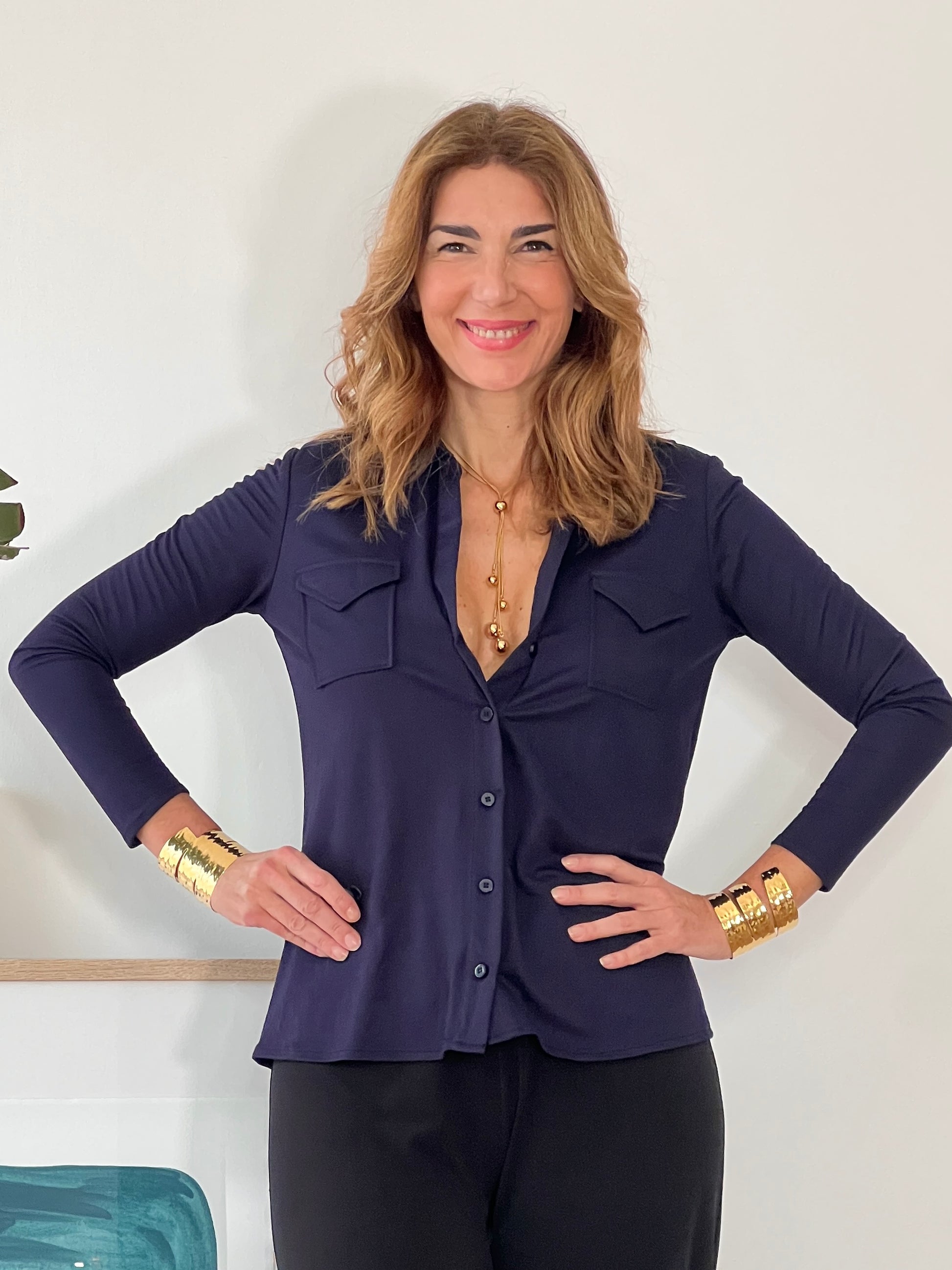 Outfit casual elegante de mujer con camisa azul marino fluida y pantalón oscuro.