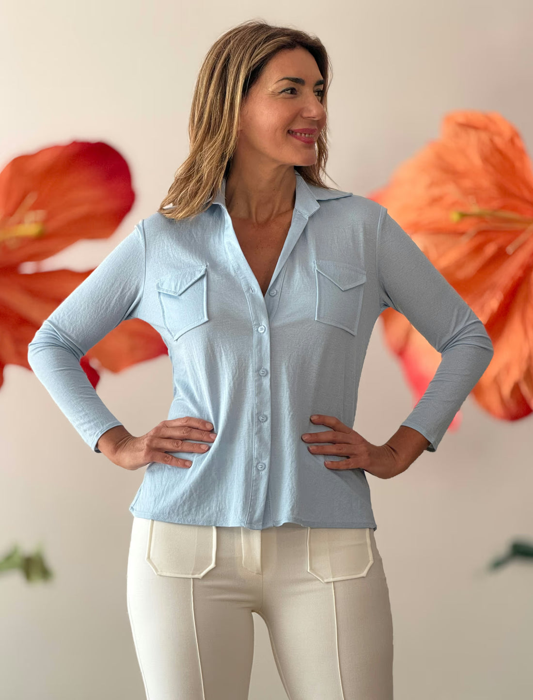 Camisa azul de mujer con cuello pico y diseño fluido favorecedor.