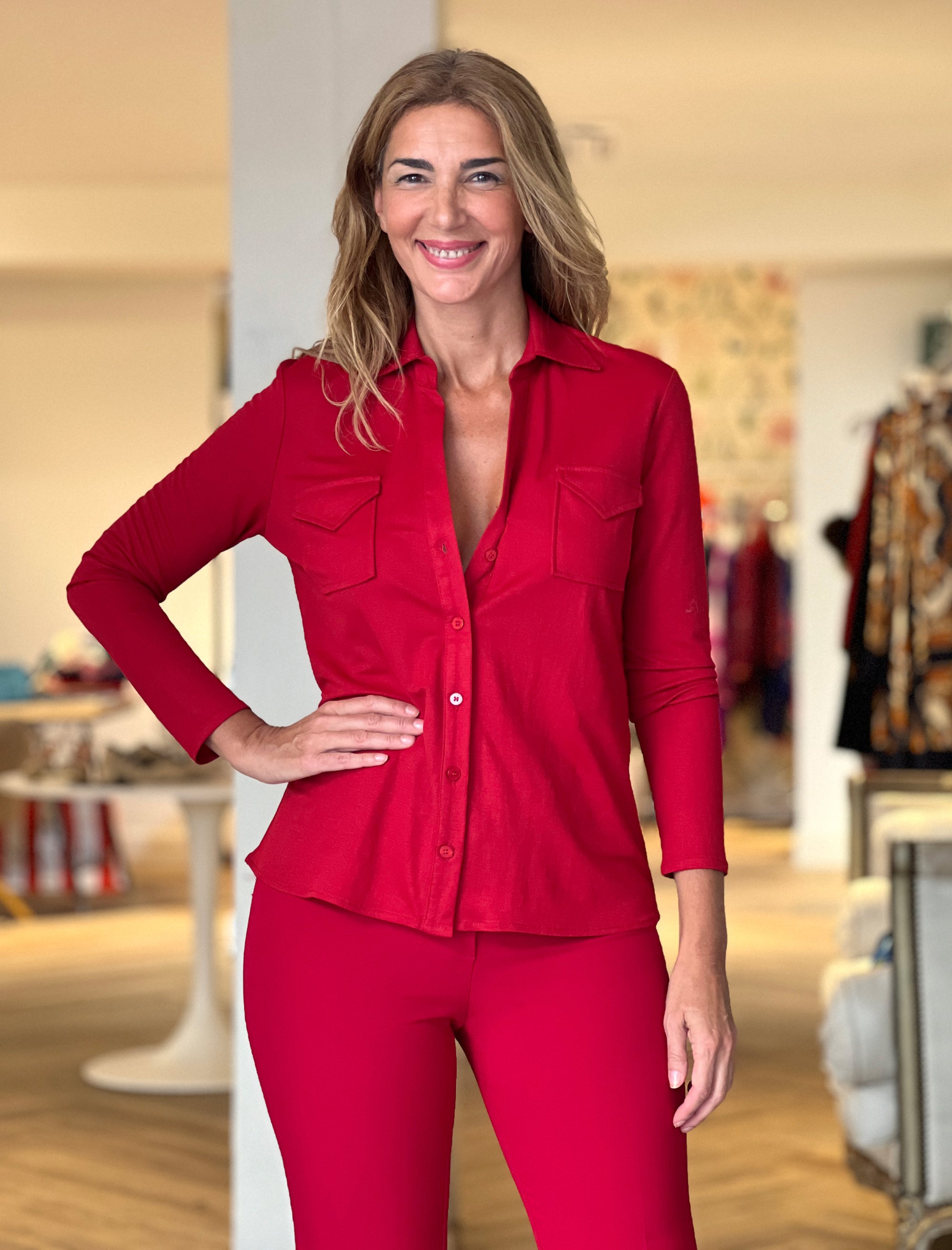Camisa burdeos elegante para mujer con cuello en pico, bolsillos delanteros y tejido fluido.