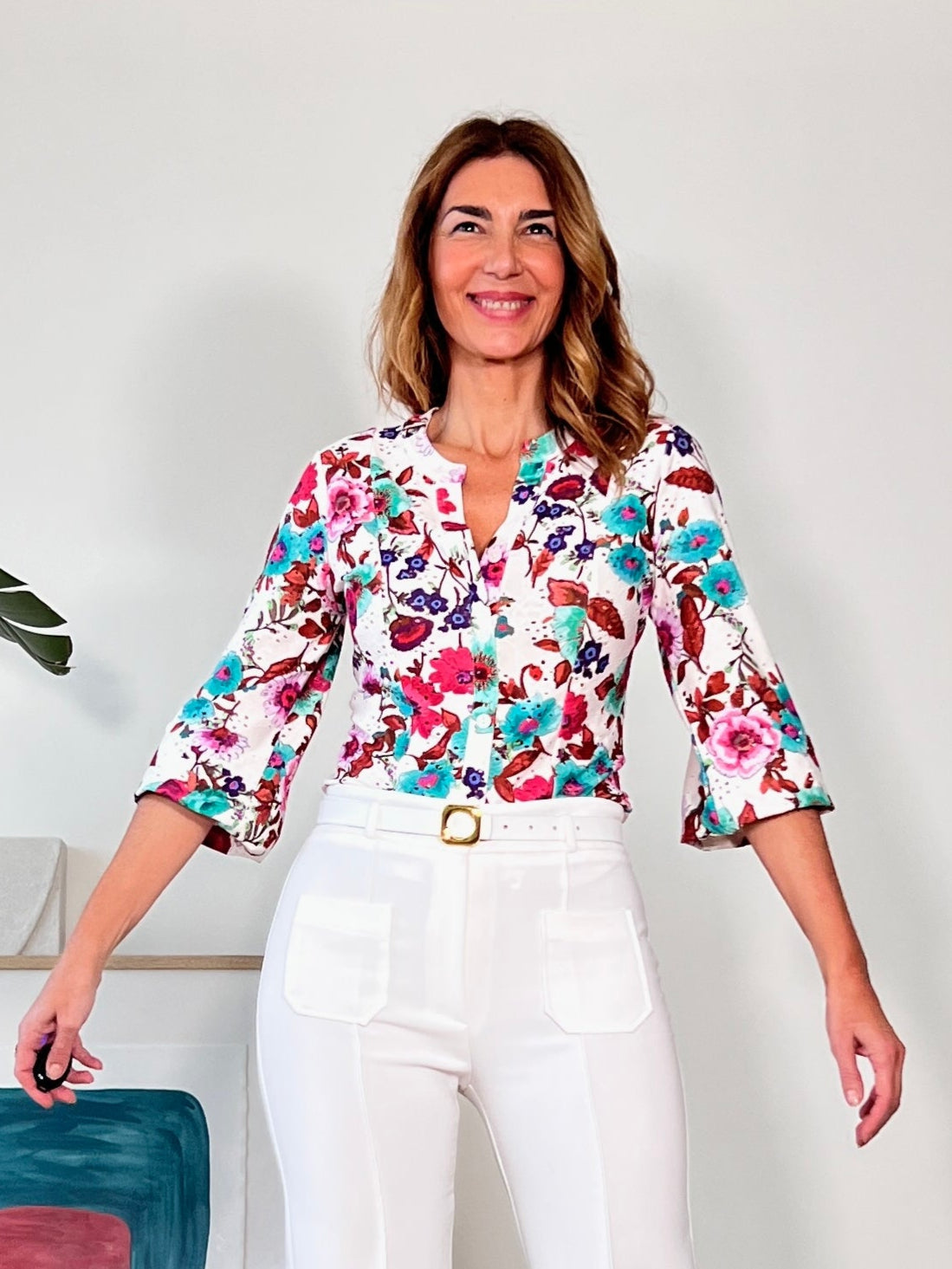 ca,isa elástica de flores perforada y combinada con pantalones blancos