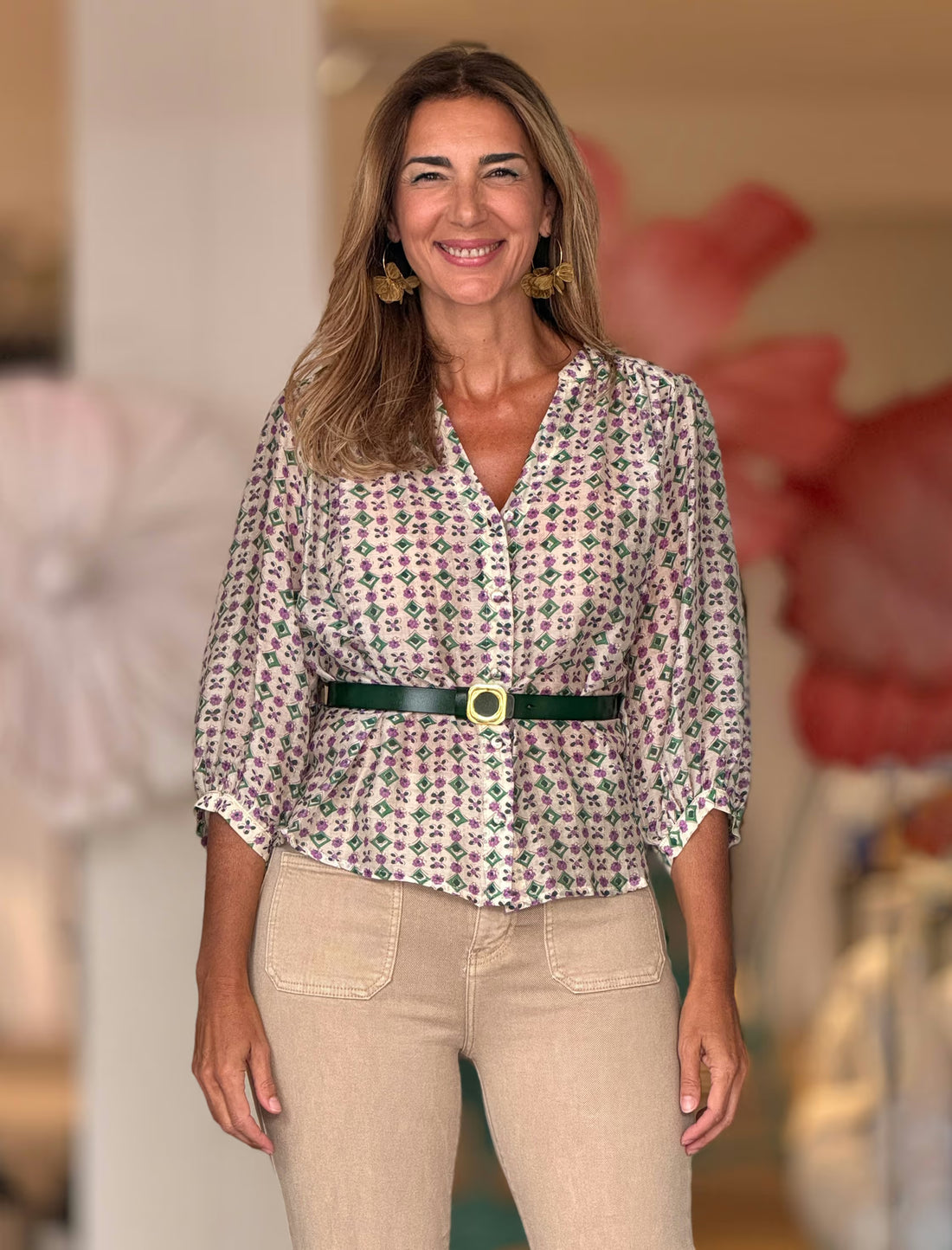 Camisa estampada Liliana floral morado y verde, combinada con pantalón beige y cinturón