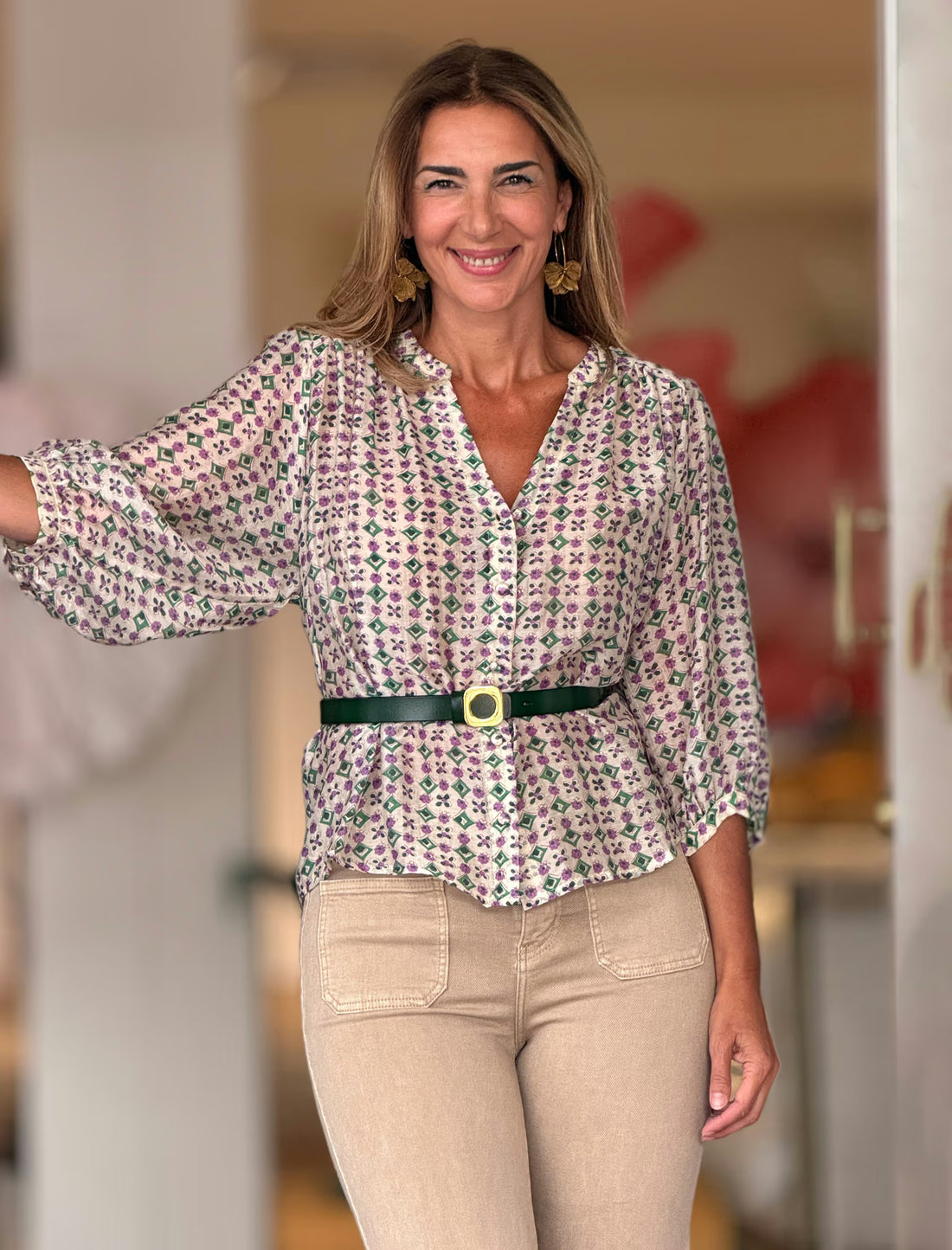 Camisa estampada Liliana floral morado y verde, combinada con pantalón beige y cinturón