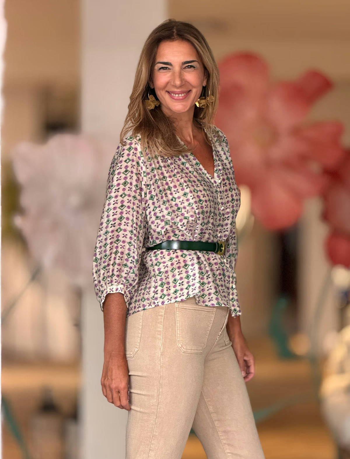 Camisa con estampado floral en tonos morado y verde sobre fondo beige