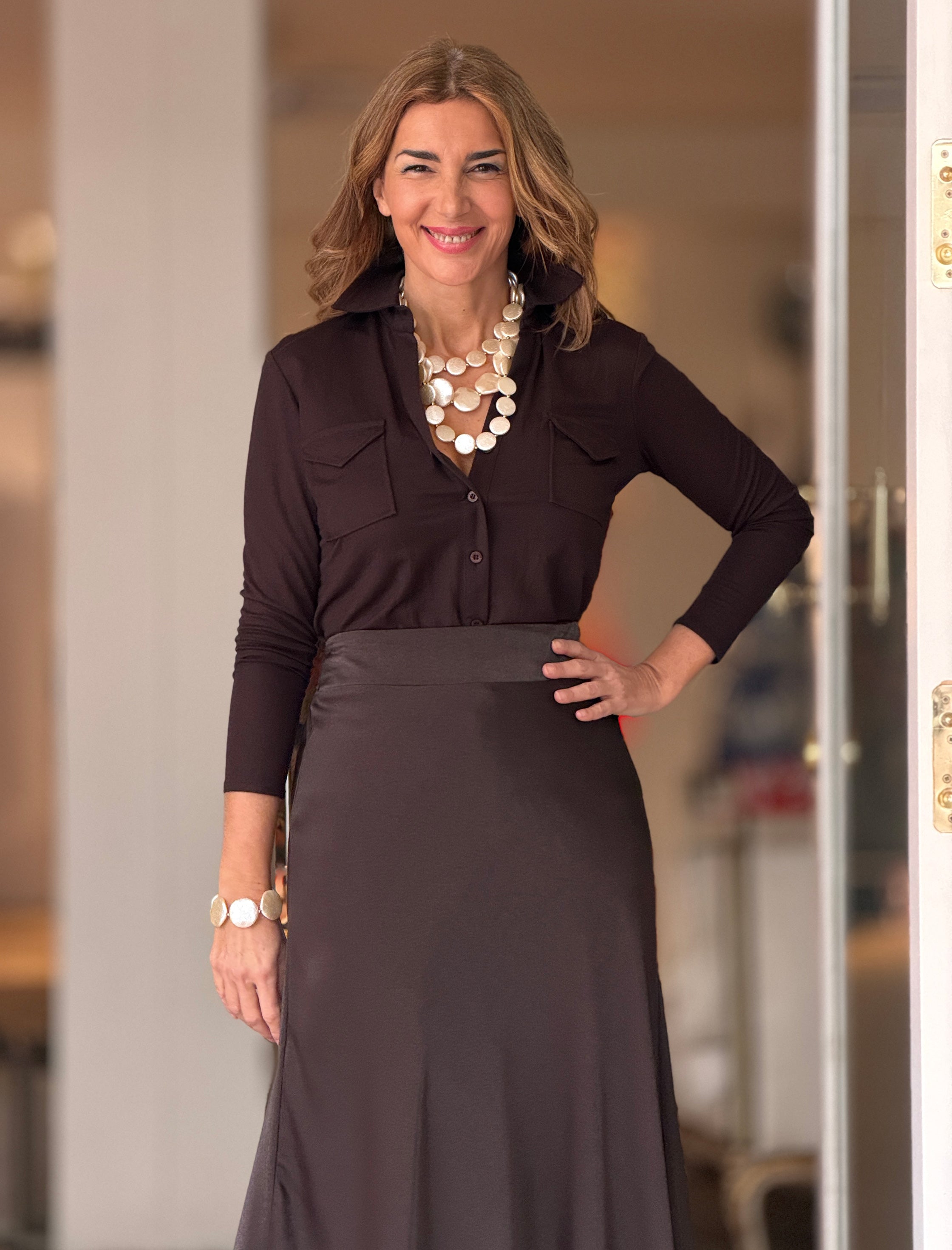 Outfit de oficina con camisa marrón para mujer y falda beige de estilo elegante.