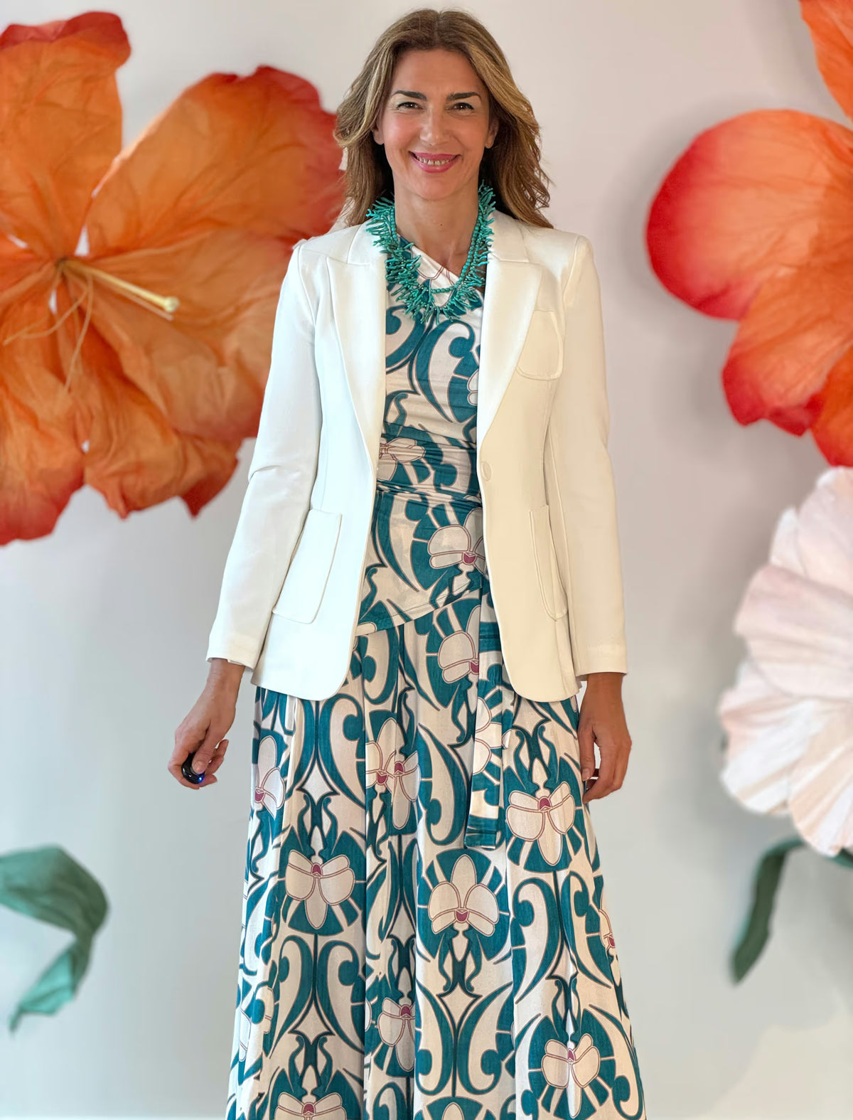 Chaqueta blanca combinada con vestido floral, look de entretiempo