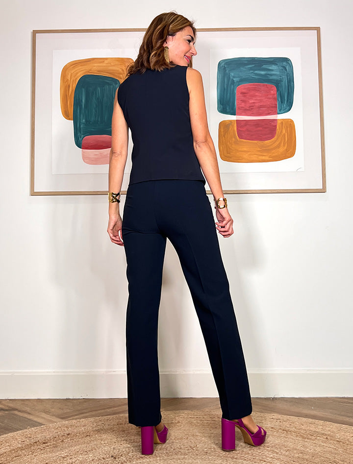 Pantalón azul marino elegante para mujer combinado con americana a juego en un look de oficina.