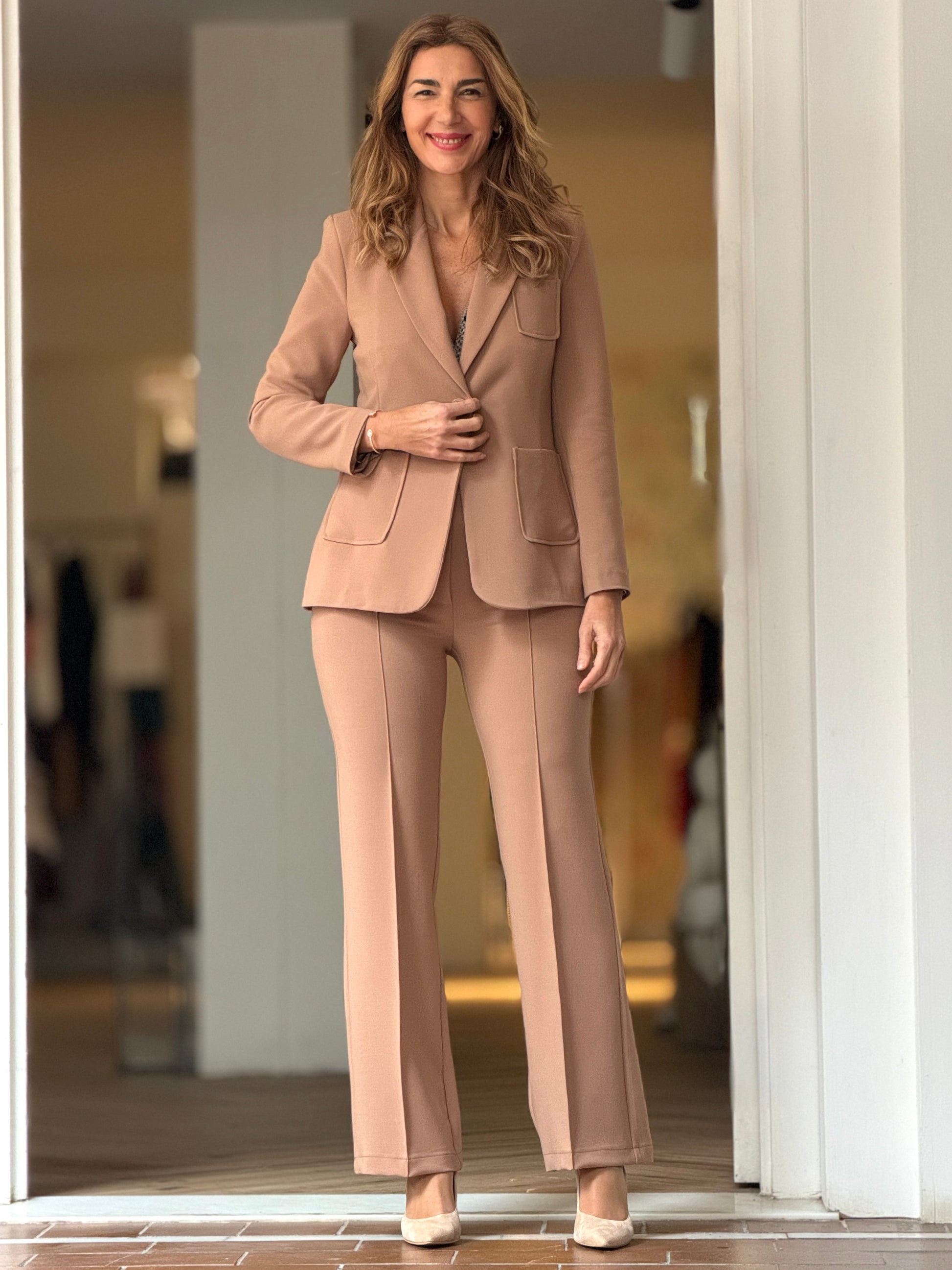 Mujer con pantalón camel elegante combinado con chaqueta a juego en un look sofisticado.