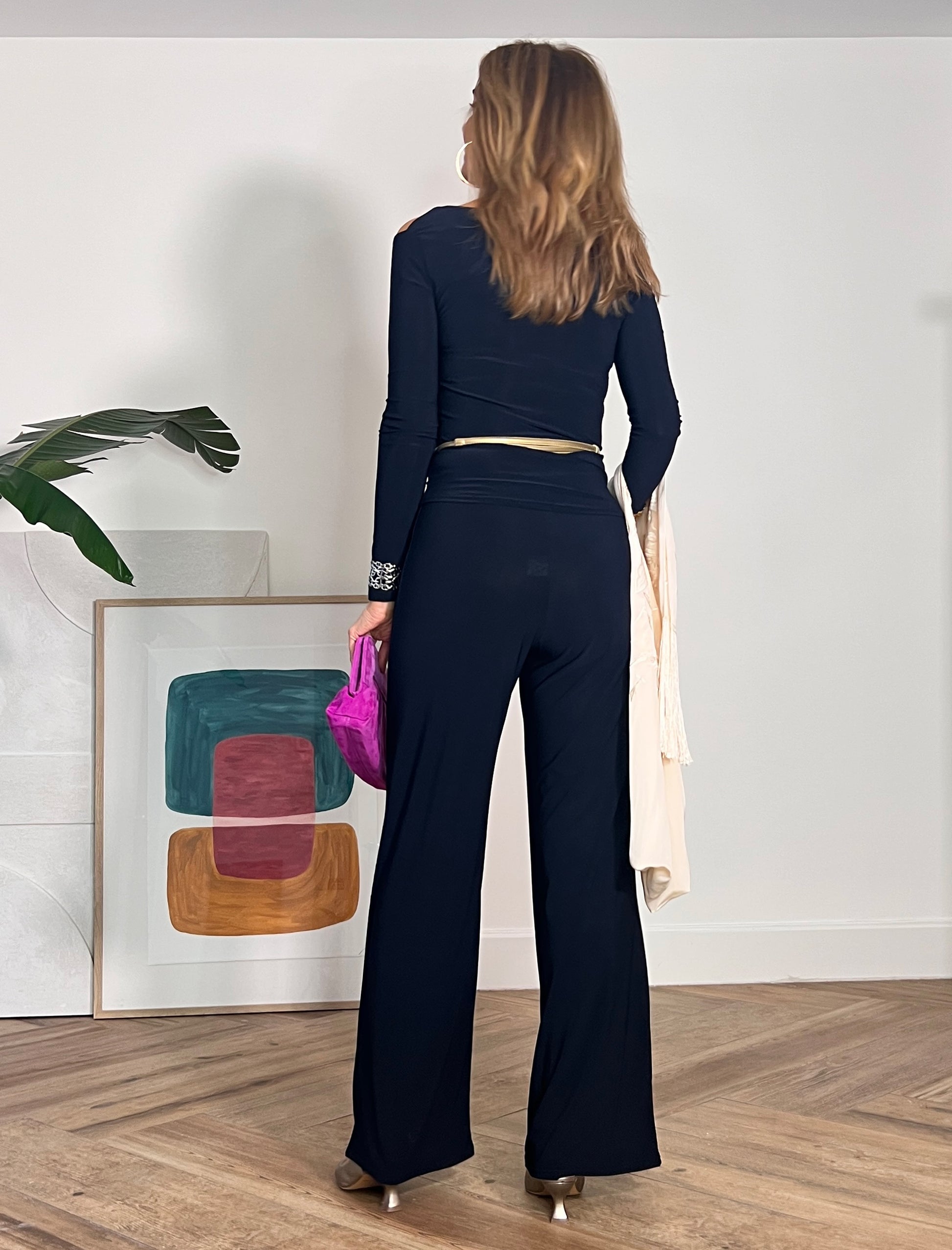 Pantalón negro de punto, vista trasera con bolso de mano
